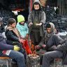 たき火で暖を取る人々＝２３日、アフガニスタン首都カブール